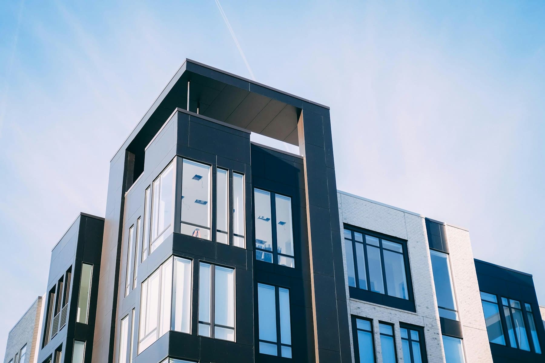 The corner of a modern apartment building with large glazed windows