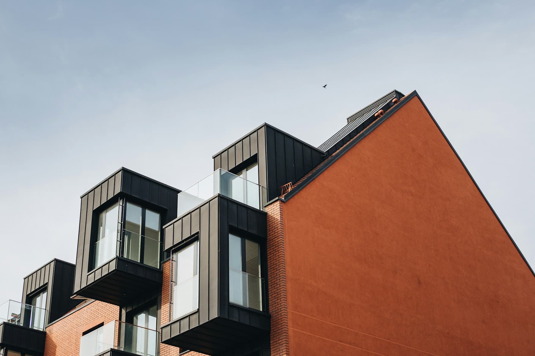 A brick apartment building with dark metal bay windows
